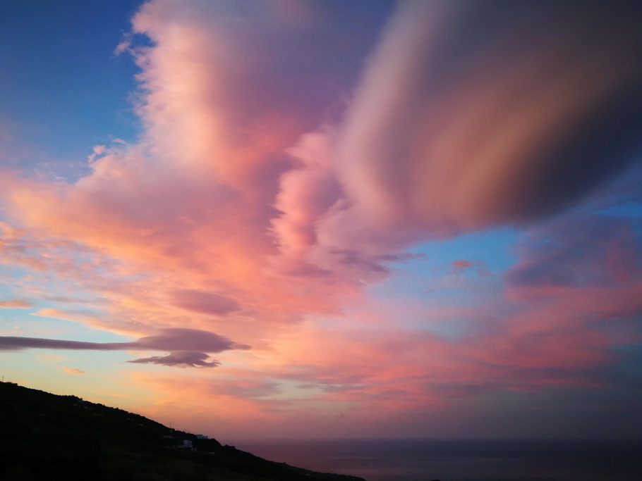 linsenfoermige-wolken-abendhimmel-gefaerbt-lachsfarben-blau-ueber-meer