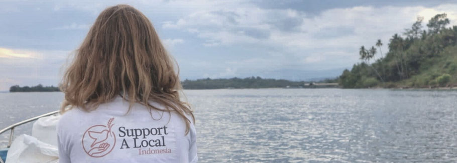 Corinna on a delivery to a fisher village wearing the t-shirt "Support a Local"