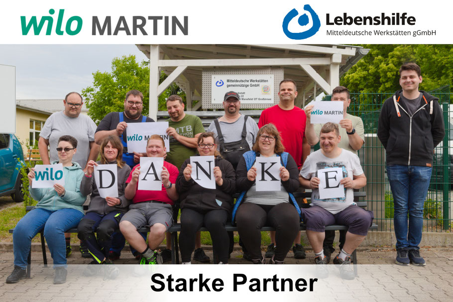 Eine Gruppe von Menschen hält Schilder mit "Danke" in den Händen.