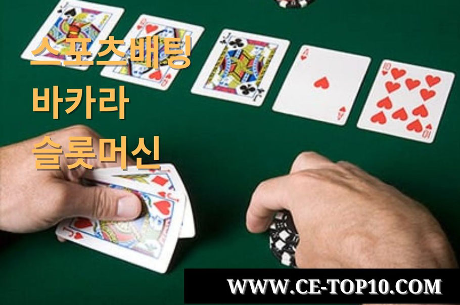 Poker chips and cards hold by a hand in green casino table game.