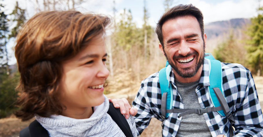 Vater und Sohn lachen gemeinsam bei einem Männers Abenteuer im Wald