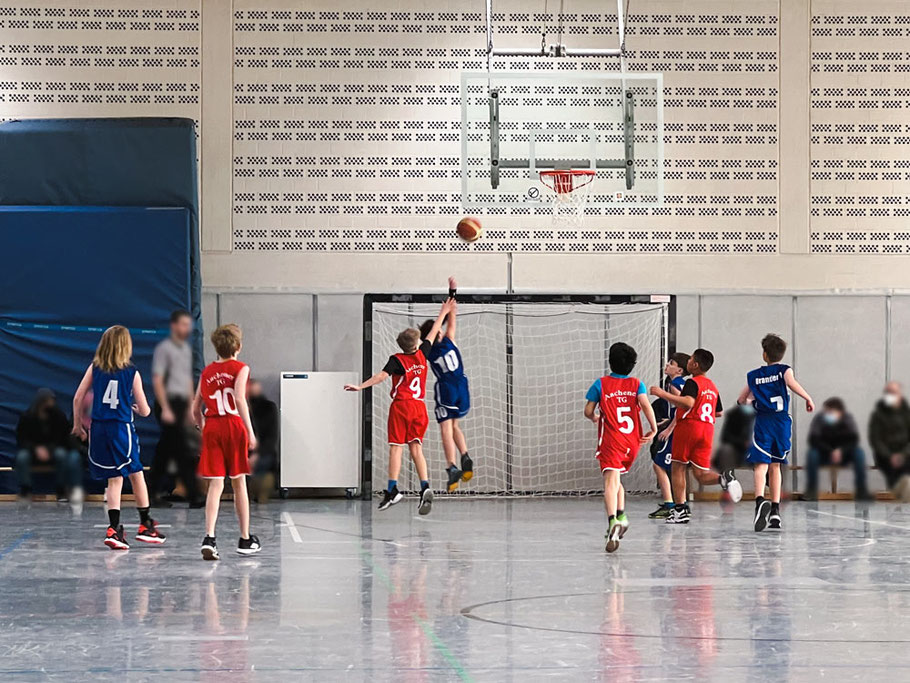 Eine Gruppe von Kindern spielt Basketball.