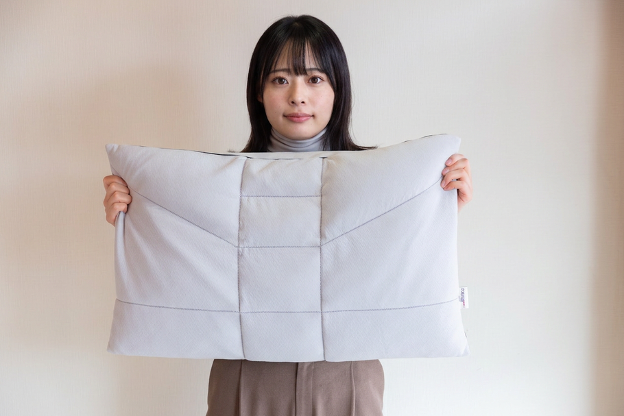 おすすめのオーダー枕をもって微笑む女性