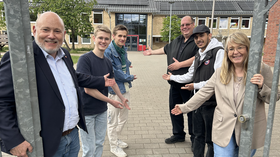 Bürgermeister Thomas Beckmann, Meik Bilmann (KJB), KJB-Vorsitzender Johann Reese, Günter Junker (Junker Sicherheit), KJB-Vorsitzender Rasheed Kabalan und Abteilungsleiterin Bildung Ilona Vries auf dem Schulhof der Comenius-Schule