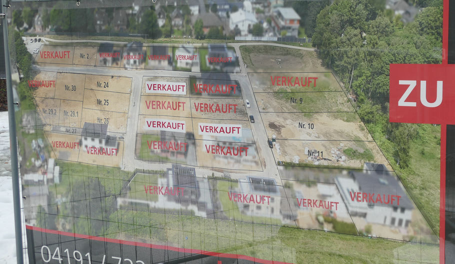 Ein Banner eines Maklers am Baugebiet macht deutlich, dass die Verwertung des Geländes voran geht. Im Zentrum (hier noch als Einzelparzellen dargestellt) entsteht das Pohl-Mehrfamilienhaus.