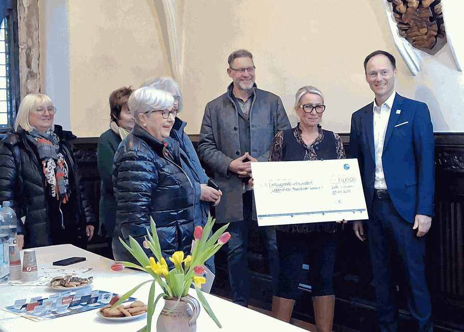 Geschäftsfüherin Frau Bachmann hält einen großen Spendenscheck der Aktion "Glanzlichter der Lutherstadt Eisleben" in der Hand