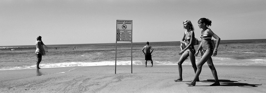 Zwei junge Mädchen spazieren auf dem Strand von Moilet et Mare in schwarzweiß als Panorama-Photographie