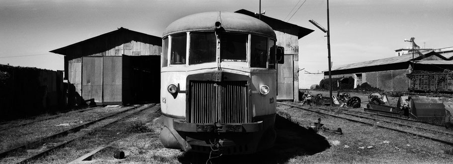 Fiat Triebwagen vor der Werkstatthalle der Asmara Ferrovia als Schwarzweißphoto im Panorama-Format