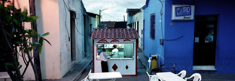 Kiosk am Abend in Baracoa, Cuba, als Farbphoto im Panorama-Format