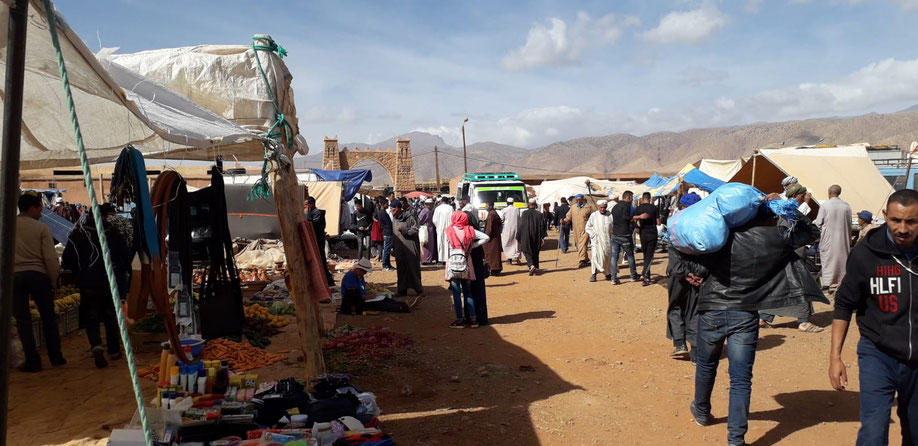 Cherchez la peintre?  assise par terre elle se fond dans le souk, quelques enfants admiratifs