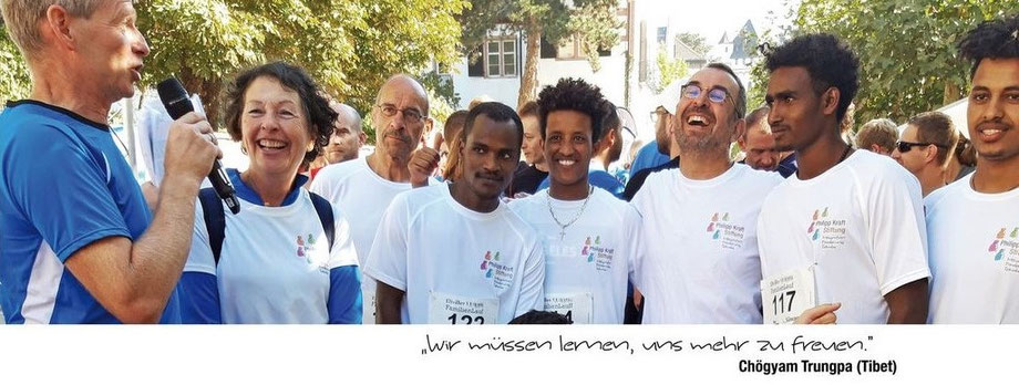Wir halten Sie über aktuelle Veranstaltungen und Projekte auf dem Laufenden: auf dem Bild die Laufgruppe der Stiftung beim Eltviller Stadtlauf. Die Teilnehmer der Gruppe unterschiedlicher ethnischer Herkunft tragen T-Shirts mit dem Logo der Stiftung.