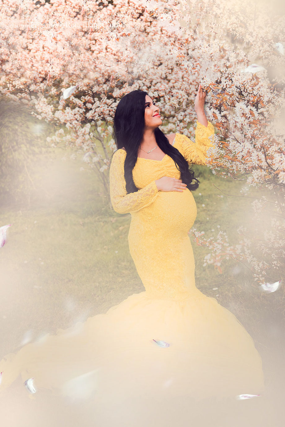 Zwangere vrouw in jurk met vallende bladen