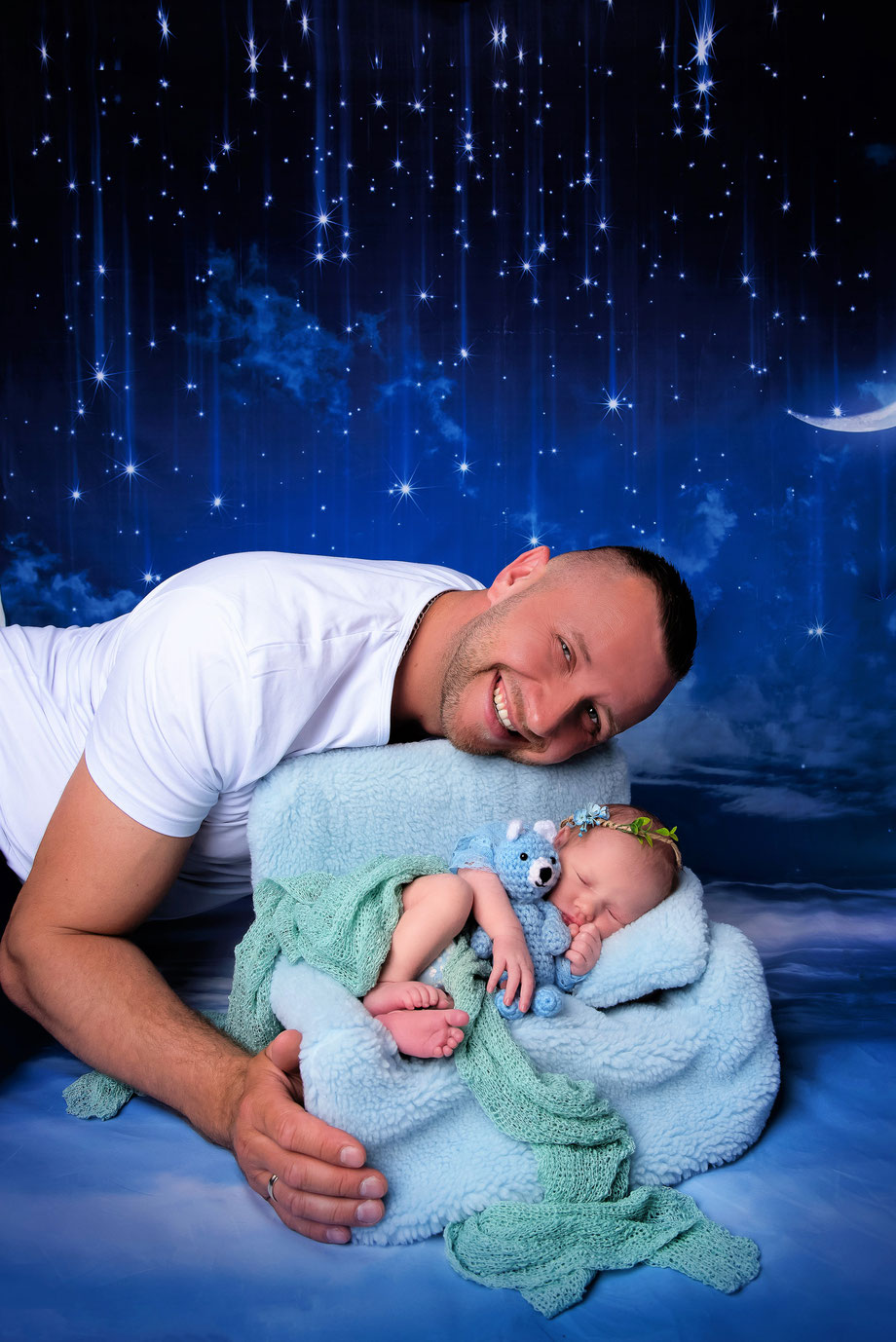 father holding newborn in scenery