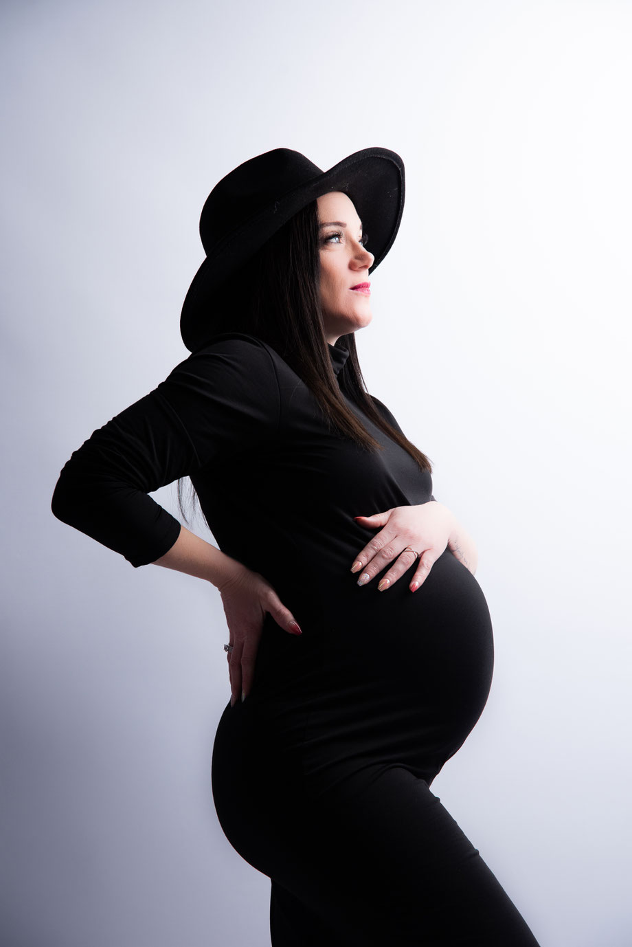 pregnant woman in black dress and hat