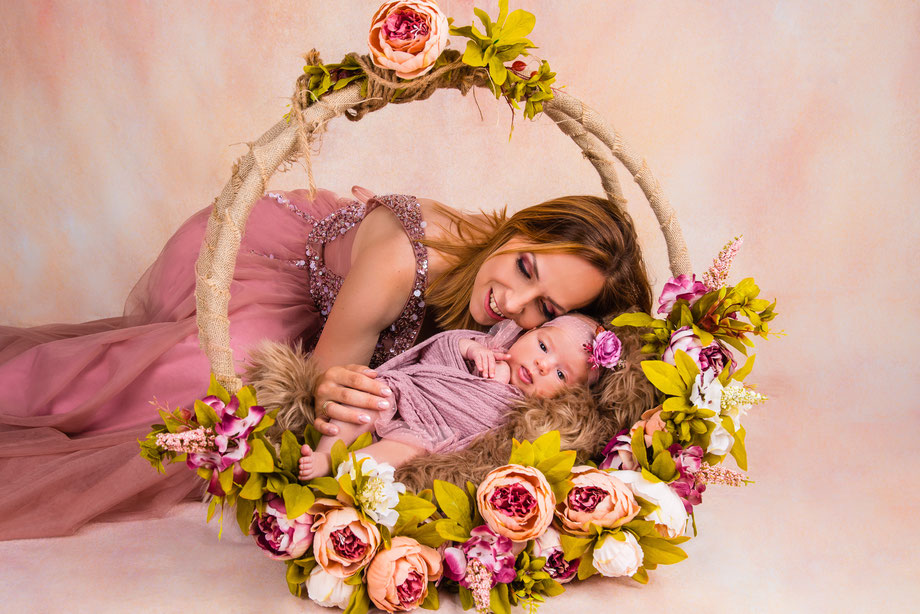 moeder en newborn poseren met bloemen