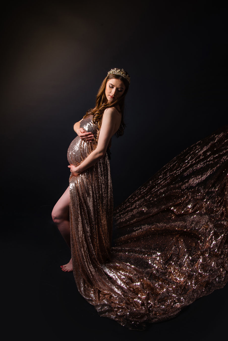 Zwangere vrouw in gouden jurk