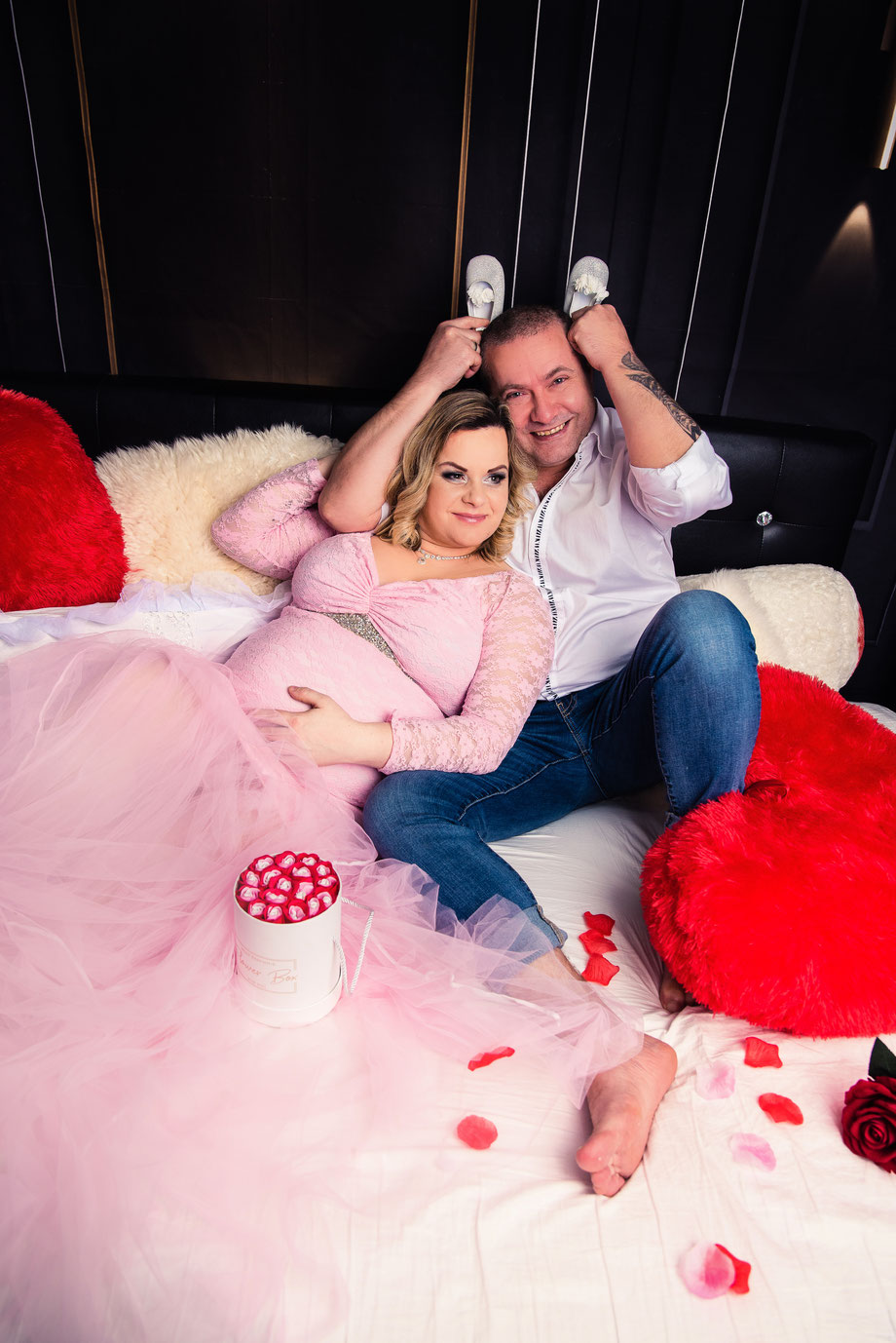 couple having fun on bed in maternity shoot