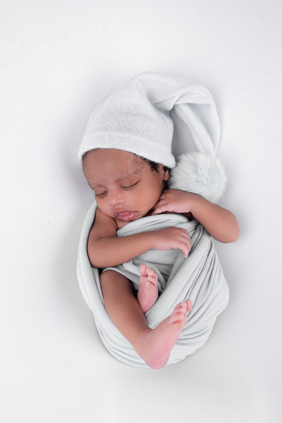 newborn boy holding grey dress