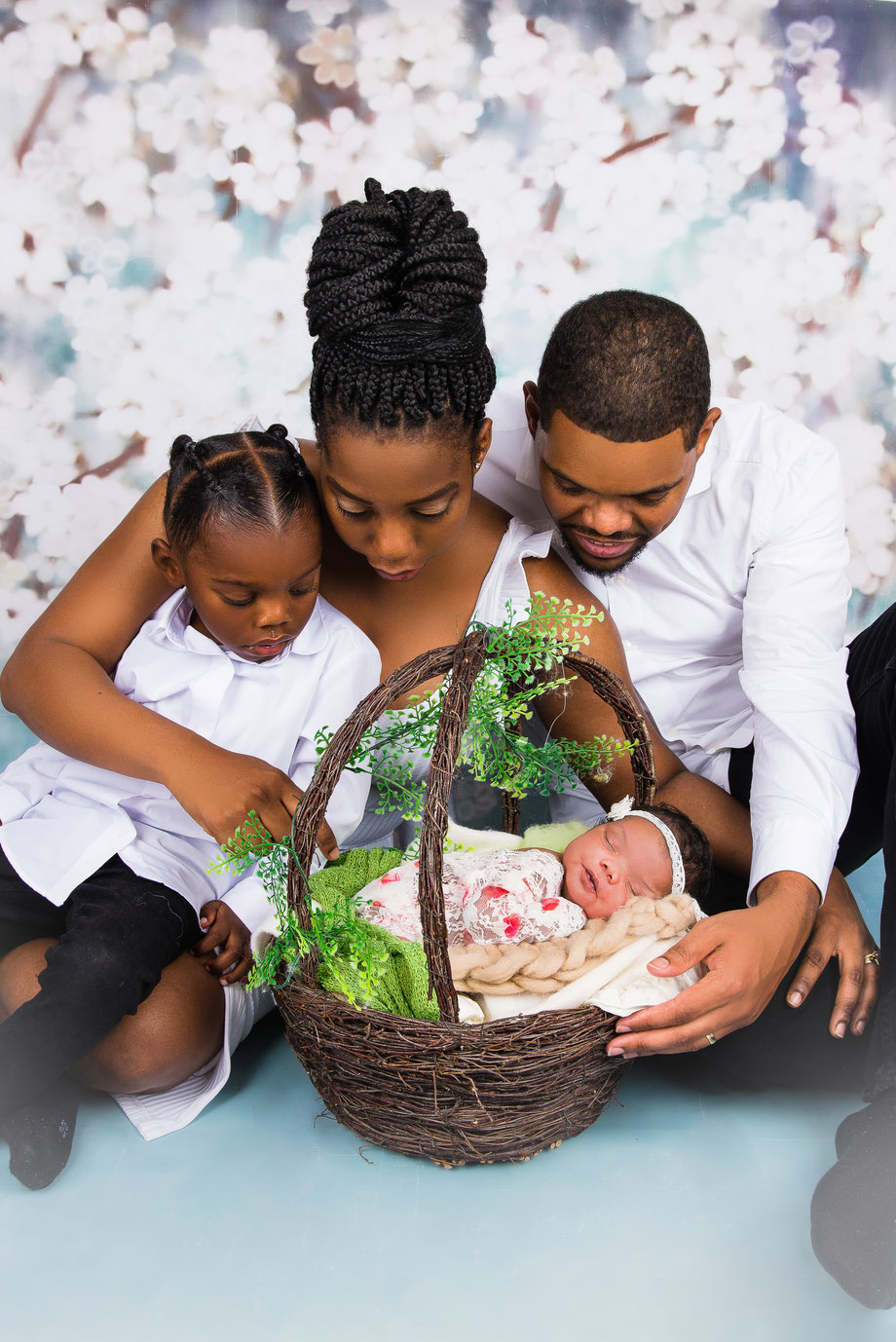 newborn girl in elegant clothes and parents looking at her