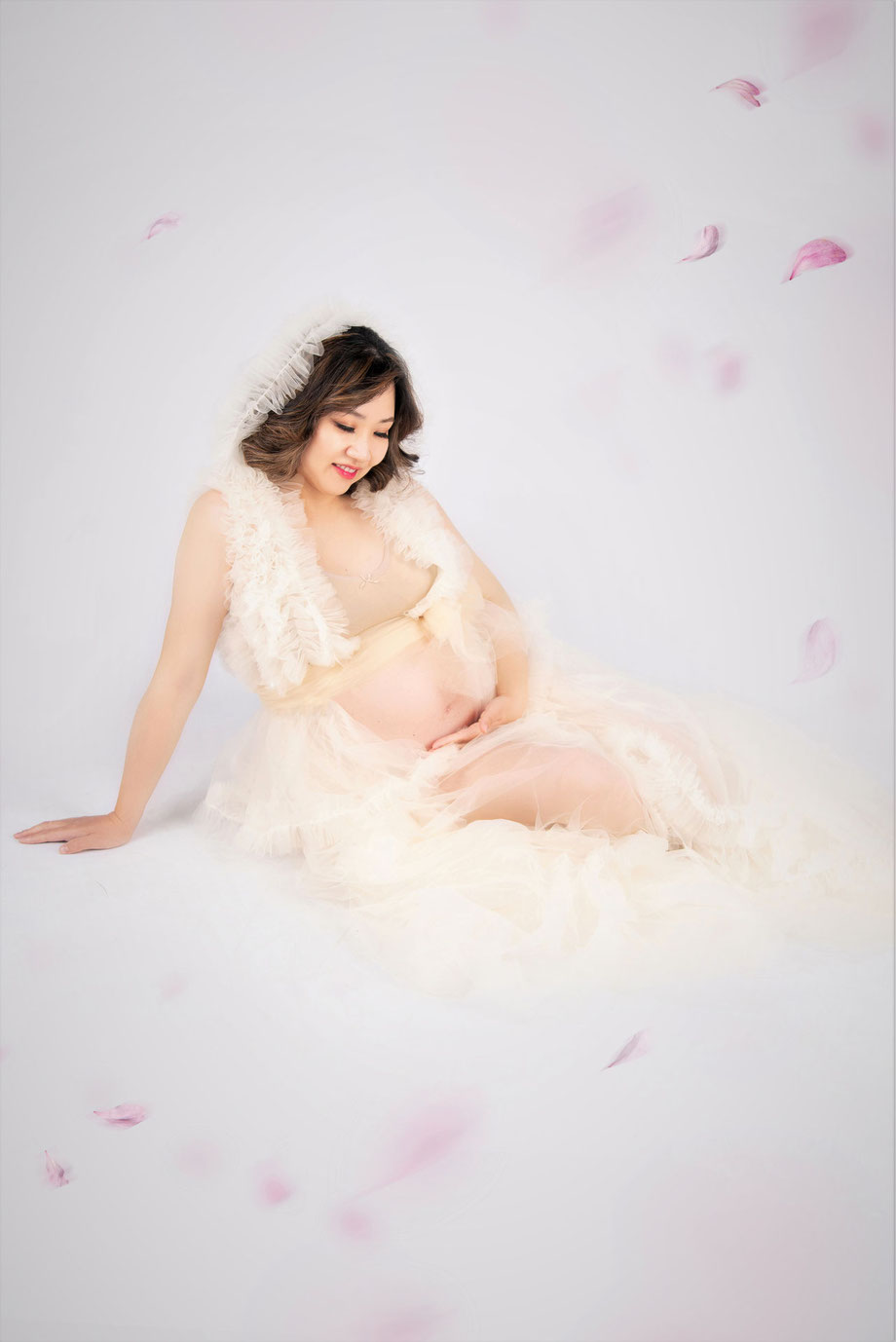 zwangere vrouw in jurk met vliegende blaadjes