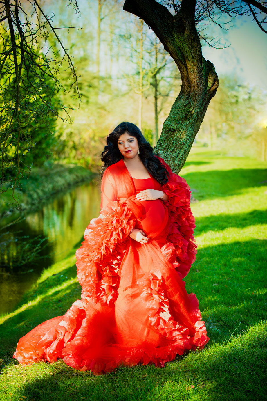 pregnant woman in red dress outside