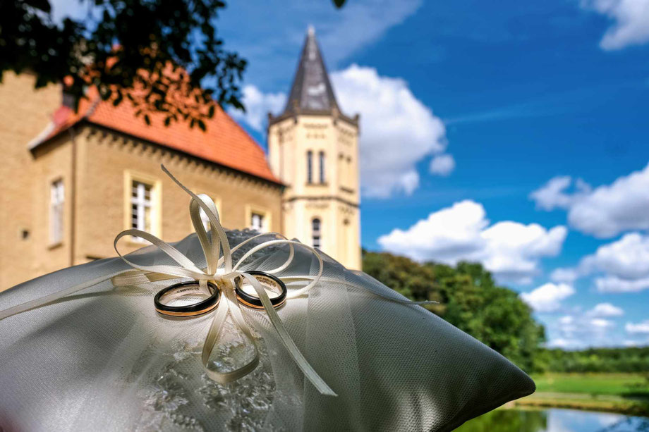 hochzeitsfotograf schloss heeren, ringekissen mit schloss im hintergrund