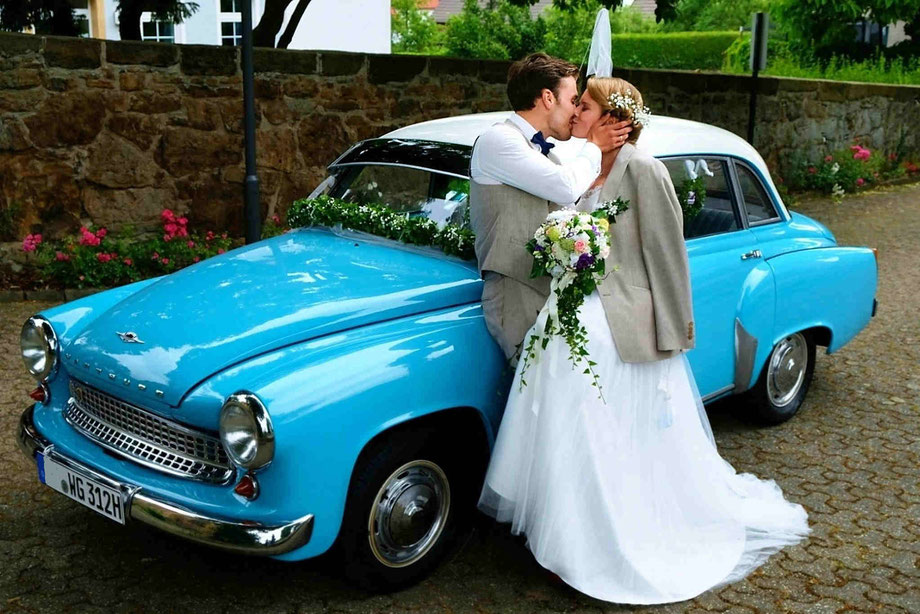 hochzeitsfotograf dülmen, fotoshooting hochzeit, brautpaar küsst sich neben blauem oldtimer