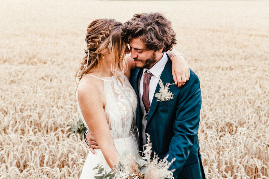 Brautpaar mit Boho-Blumenstrauß in einem Kornfeld; is-fullwidth