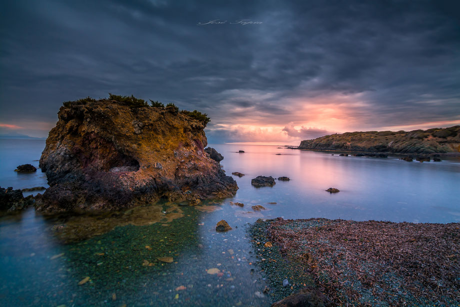 "DISTANT LIGHTS". A corner in Mediterranean coast at sunset a stormy day with the water in total calm, Andalusia, Spain.