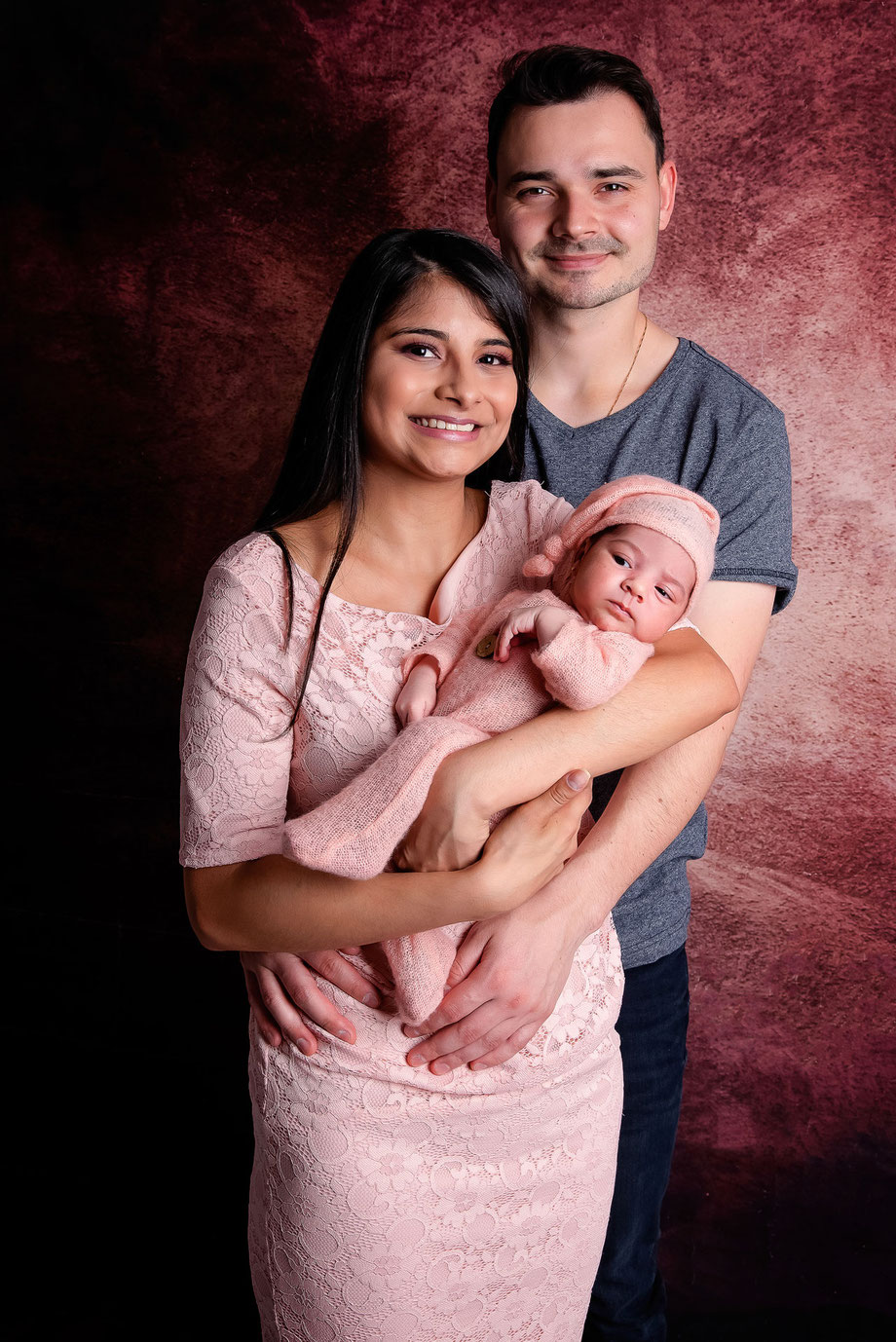 baby shoot with parents and backdrop