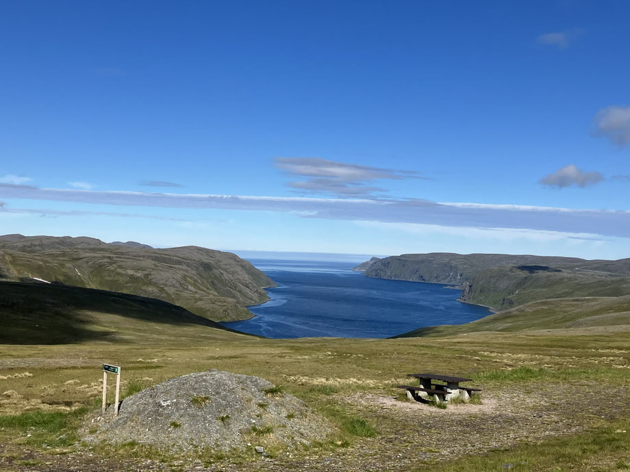Bikepacking auf Magerøya in Norwegen mit Blick über einen Fjord Richtung Nordkap, karge Hochebene und arktische Küstenlandschaft.