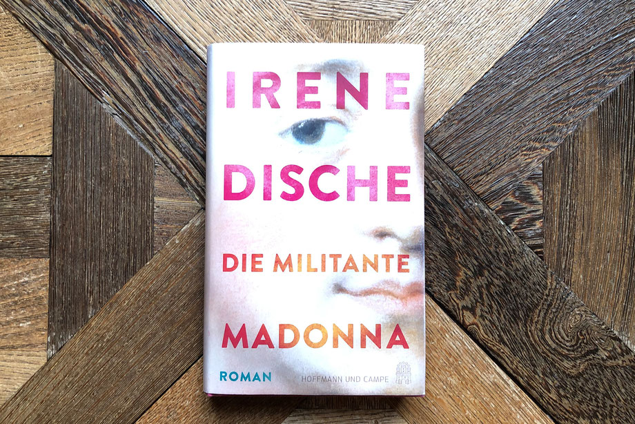 "Die militante Madonna" von Irene Dische liegt auf einem antiken Parkett.