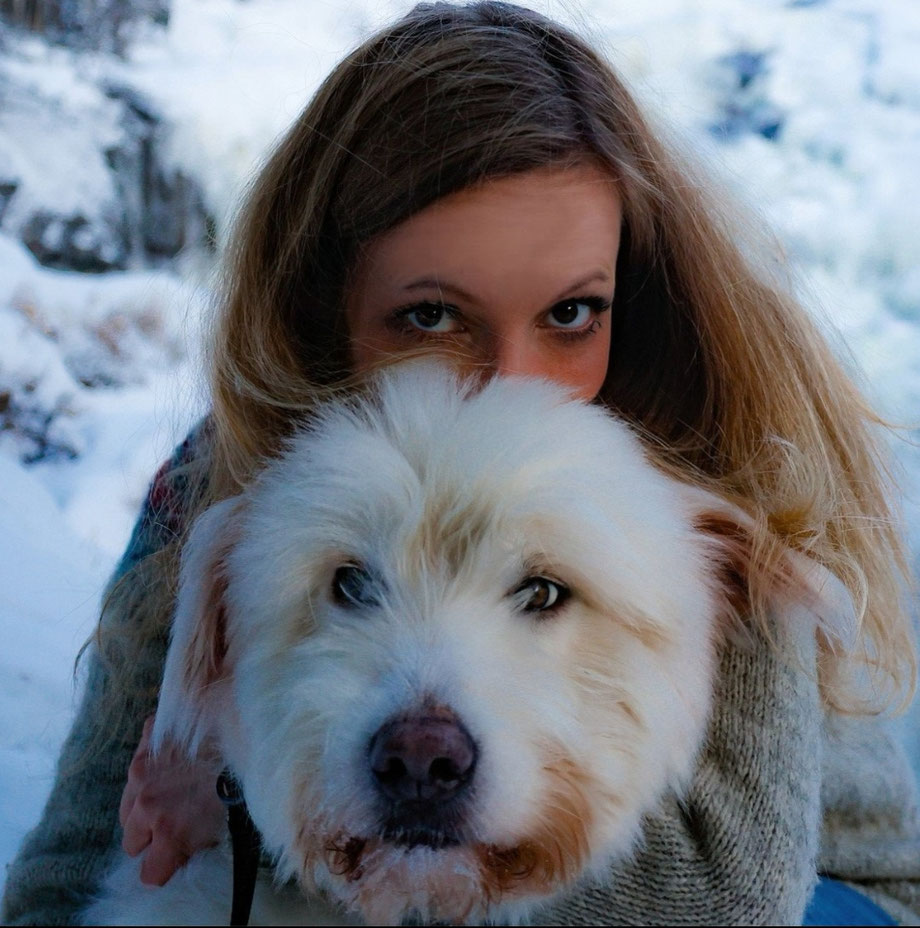 Frau mit weißem Hund im Schnee