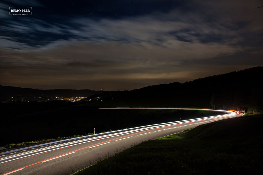 Strasse bei Nacht mit Lichtern von Autos