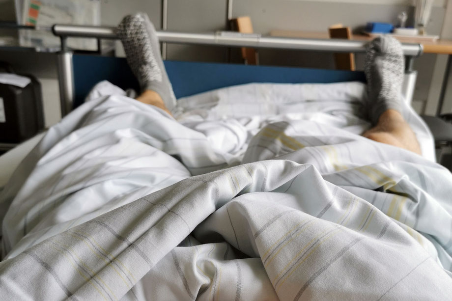 Mann im Krankenhausbett die Füße schauen aus der Decke