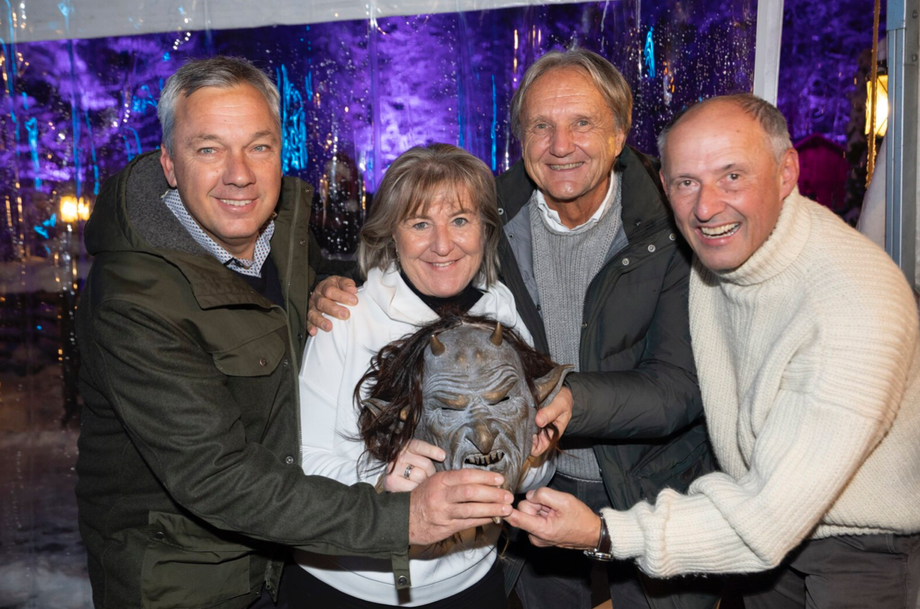 Besucher:innen der mystischen Krampusshow posieren gemeinsam mit einer Krampusmaske.