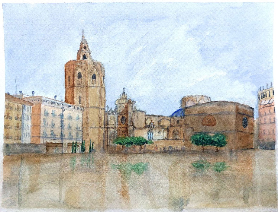 Plaza de la Reina con la Catedral y el Miguelete, edificios históricos y pavimento húmedo bajo cielo suave.
