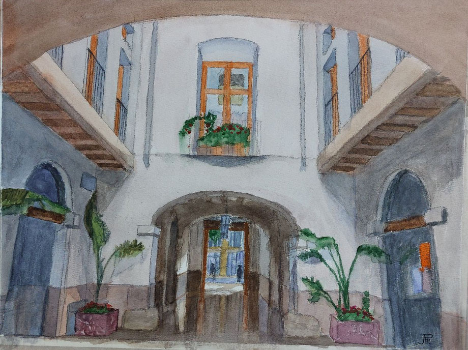 Patio con arco central, balcones de madera, plantas en macetas y luz suave entrando desde el fondo.