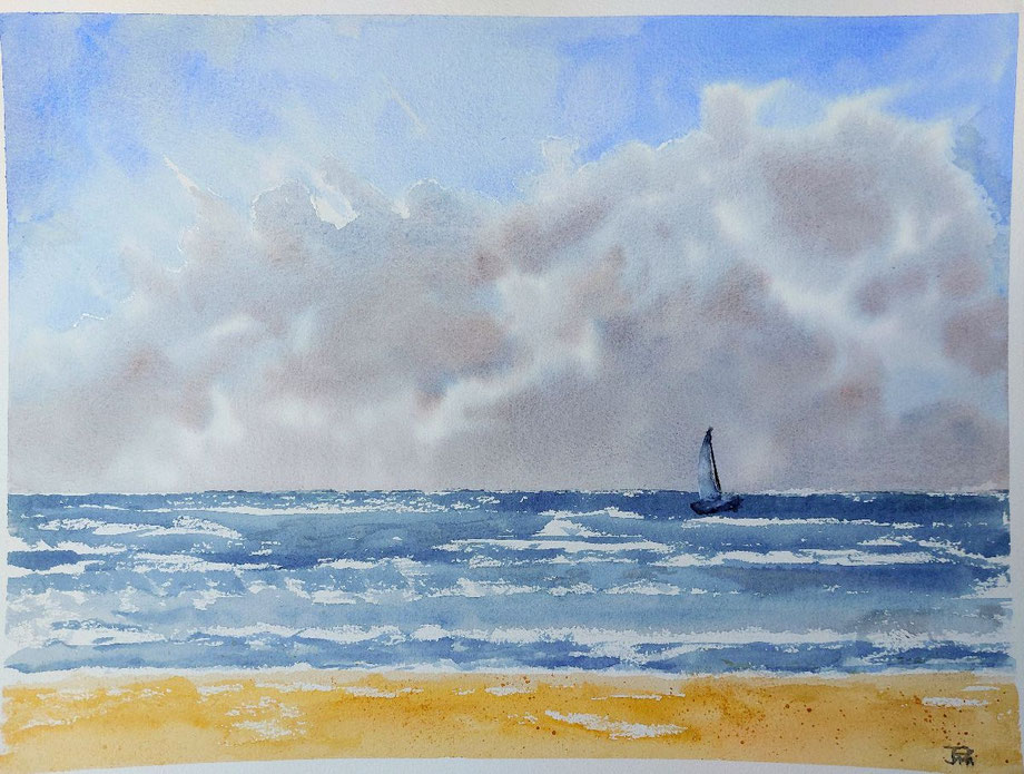 Playa con arena dorada, mar agitado, un velero en la distancia y cielo parcialmente cubierto.
