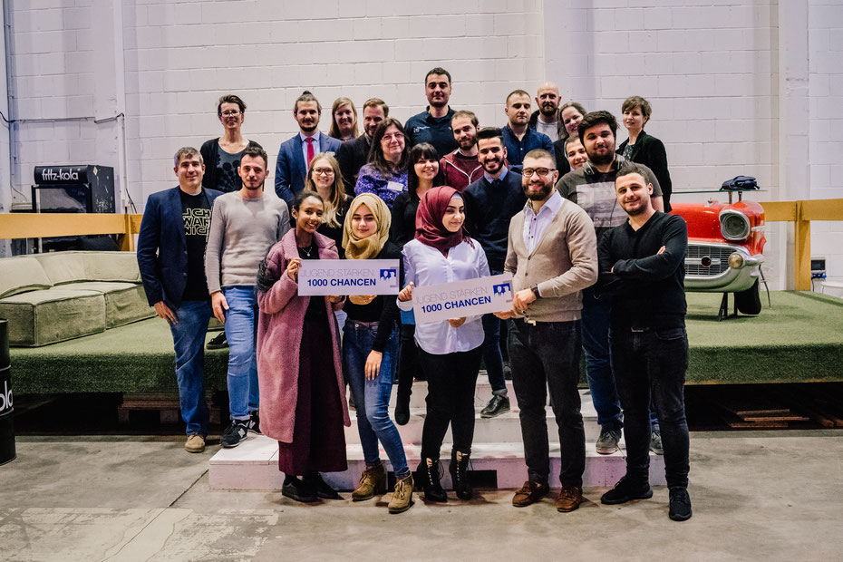Gruppenfoto von Teilnehmenden des Aktionstages. In der vorderen Reihe werden Schilder mit der Aufschrift "Jugend stärken - 1000 Chancen" gehalten.