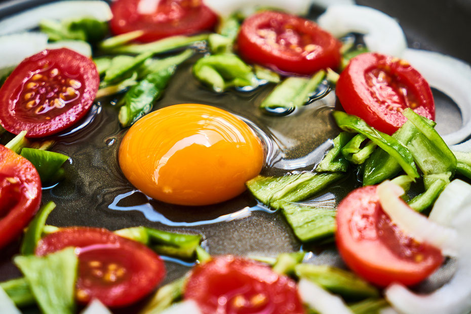 Nur das Beste für die Queen: frisches Hühnerei mit honiggelbem Dotter, sonnengreifte rote Tomaten und grüne Paprika für das Omelett aux Tomates (Rührei mit Tomaten)