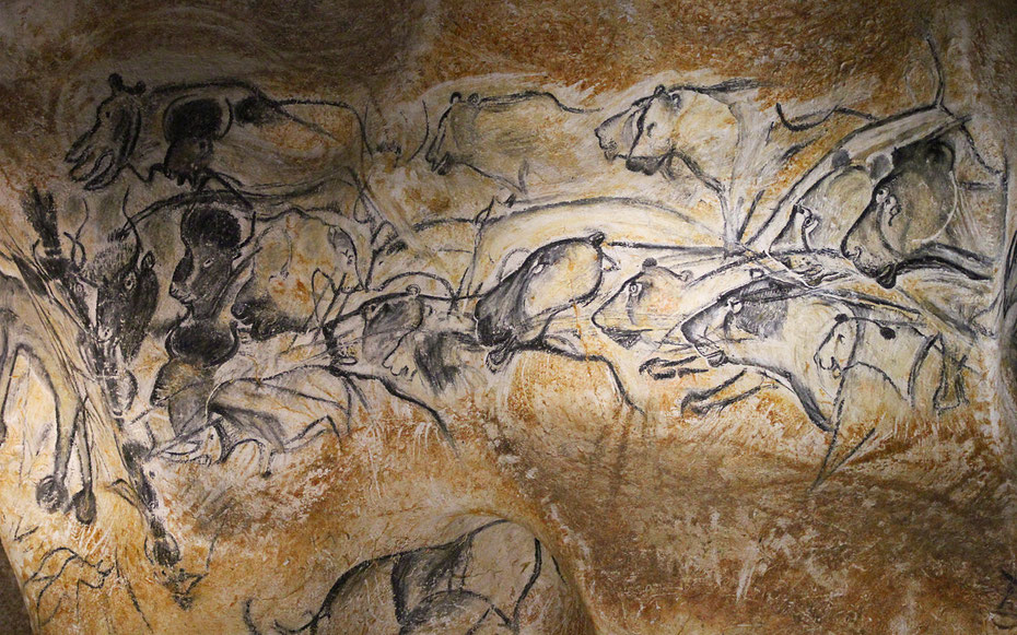 世界遺産「ショーヴェ＝ポン・ダルク洞窟として知られるアルデシュ県ポン・ダルクの装飾洞窟」のペトログラフ。中央から右に描かれているのはホラアナライオンで、左のオーロックスやバイソン、サイを追い掛けている（写真はレプリカ洞窟ショーヴェ２）