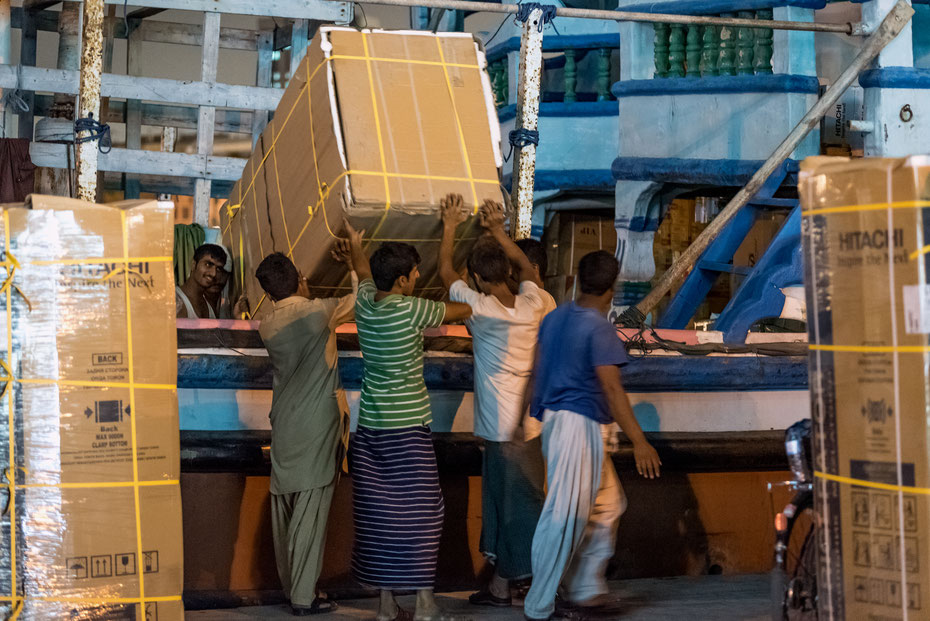 Trotz aller Modernität im Emirat werden Waren in der Region größtenteils noch mit traditionellen Dhows transportiert. Die Schiffe werden mitten in der Stadt nachts beladen und machen sich im Morgengrauen auf zu ihren Zielen im Persischen Golf. 