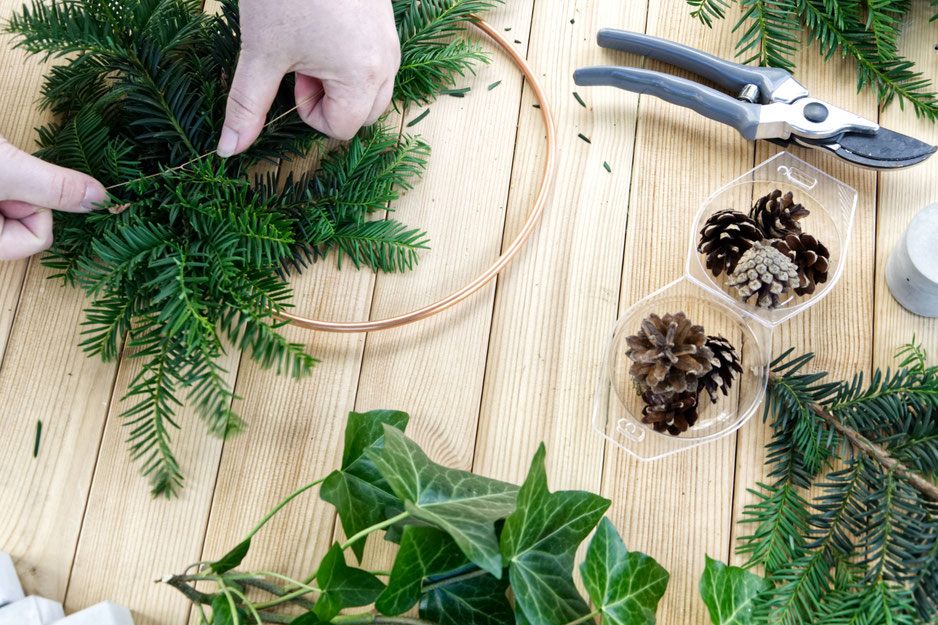 Attaching evergreens to the copper ring for DIY winter wreath by PASiNGA decor ideas with concrete