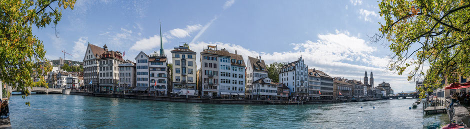 Panoramic view of the Limmatquai in Zurich. The blue-green Limmat in the foreground.