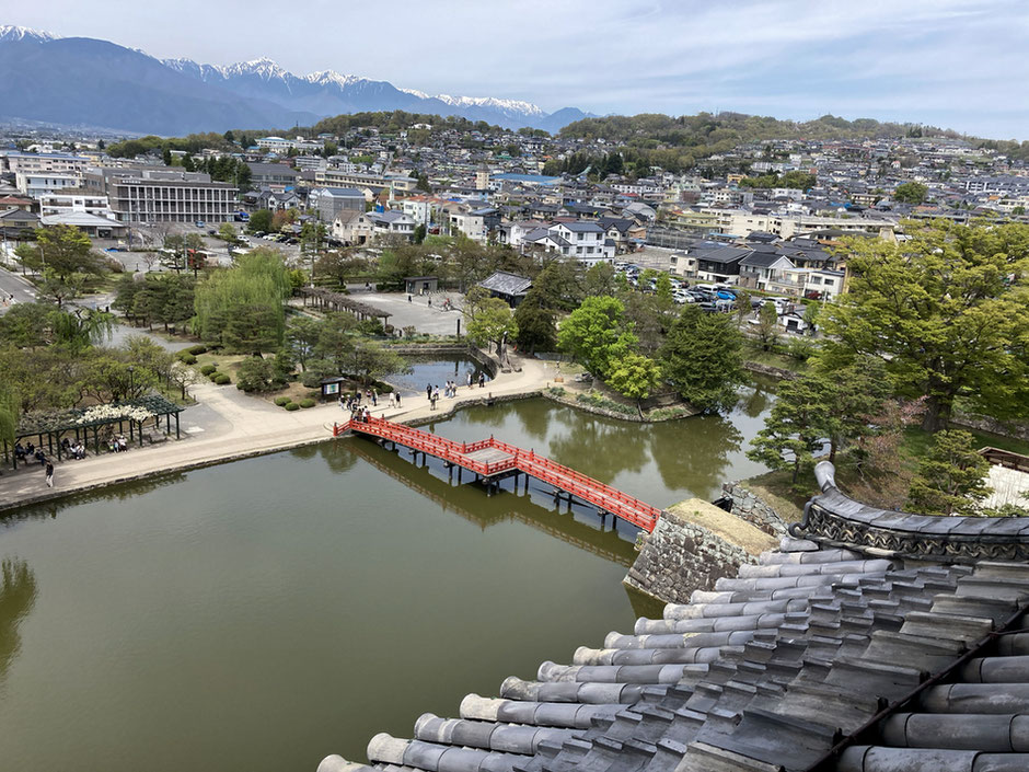 松本城最上階からの眺め。内堀の先に松本市街地、そして奥には北アルプスが横に長く続いている
