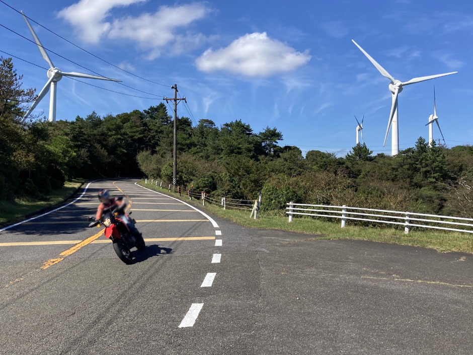 巨大風車を横目にコーナリング。延々10kmほどのワインディングロードが続く