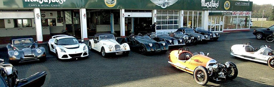 Merz & Pabst Gebäude mit Fahrzeugen davor (Morgan, Lotus)