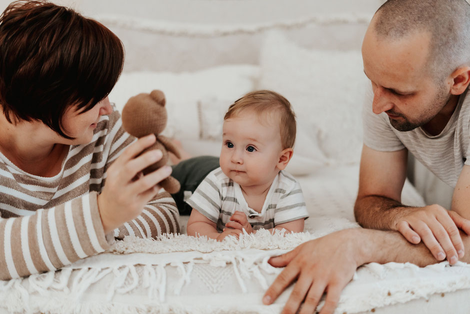 baby-liegt-auf-dem-bauch-mit-seinen-eltern-waehrend-fotoshooting-Babyfotograf-dresden