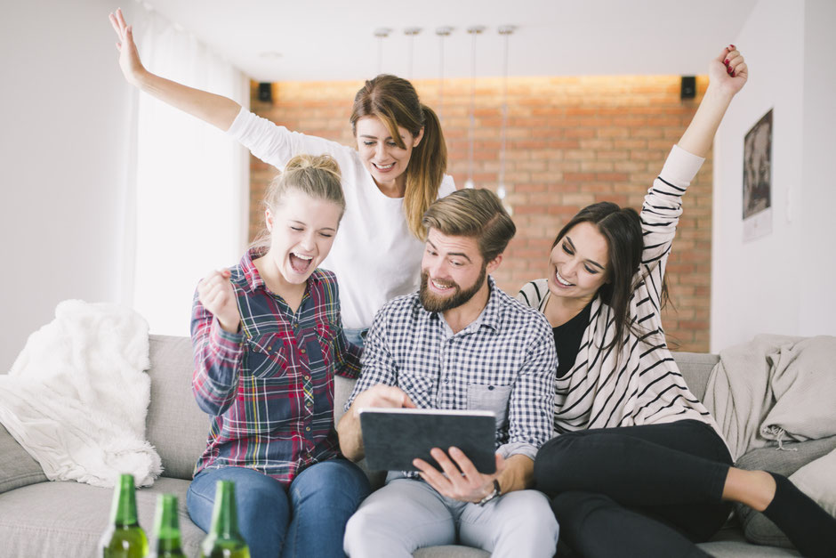 a group of people looking at a digital tablet with happy smiling faces